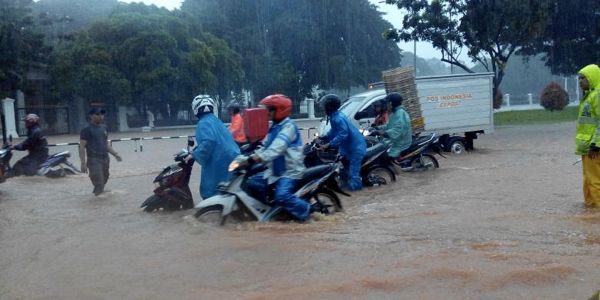 Warga kota harus bersusah payah melewati banjir