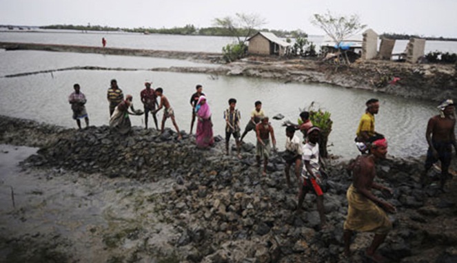 Penduduk Bangladesh membangun dinding untuk melindungi tempat tinggal mereka dari banjir dan air pasang [Image Source]