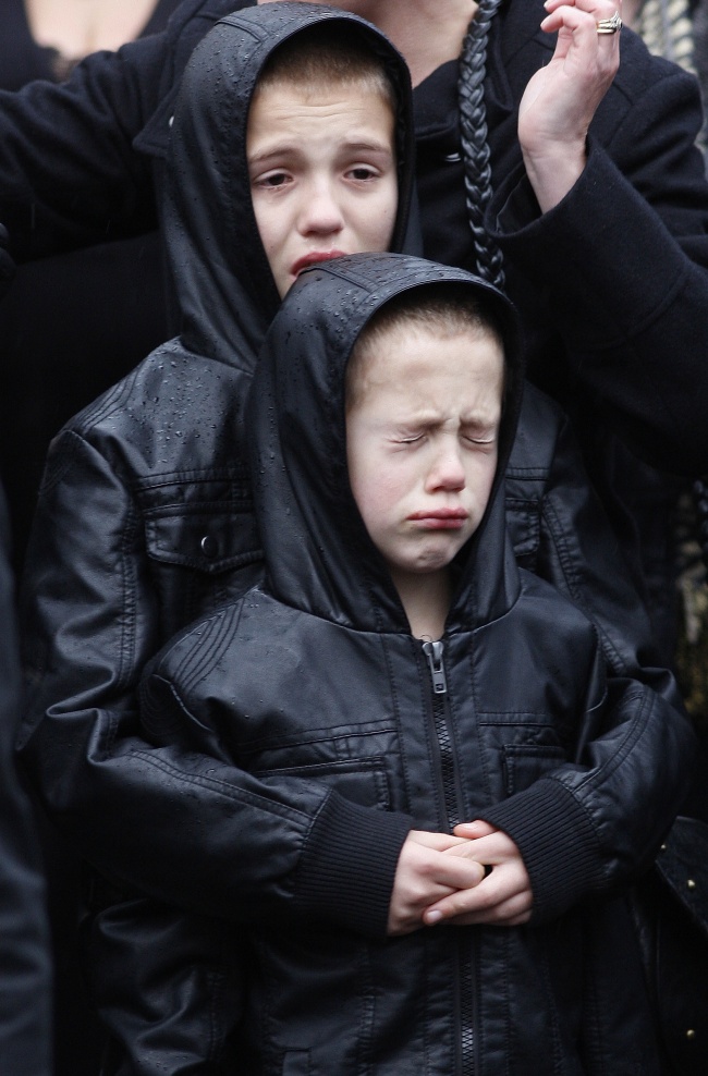 Bocah laki-laki menangis di pemakaman tentara yang meninggal [Image Source]