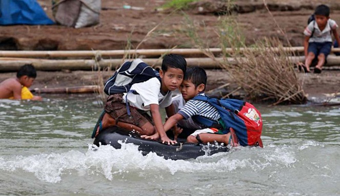 Tak bisa berenang, anak-anak Manila ini pakai ban untuk ke sekolah [Image Source]