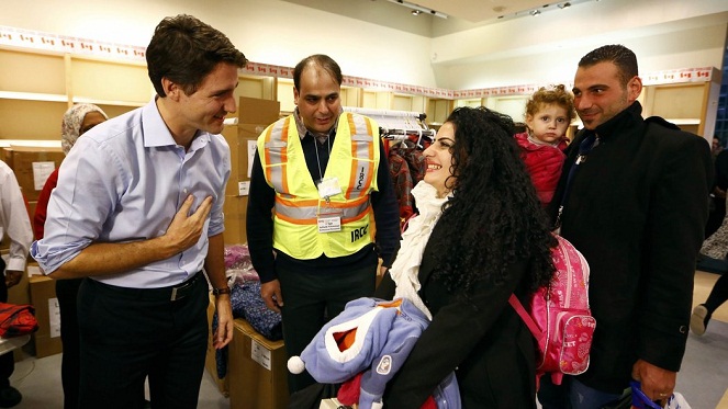 Momen saat Justin Trudeau menyambut para pengungsi Suriah [Image Source]