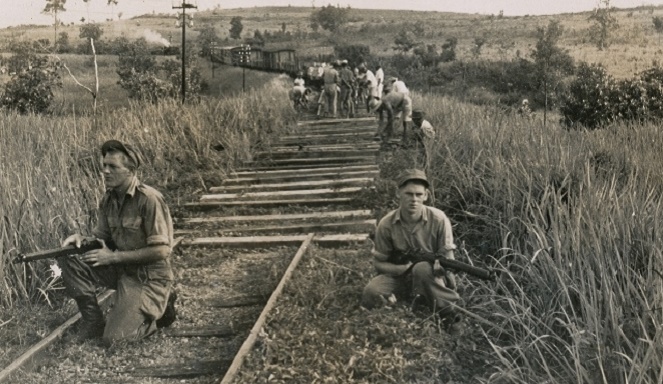 Dua tentara sedang berjaga di rel yang tengah dibenahi [Image Source]