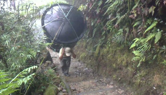 Seorang porter membawa tandon air [Image Source]