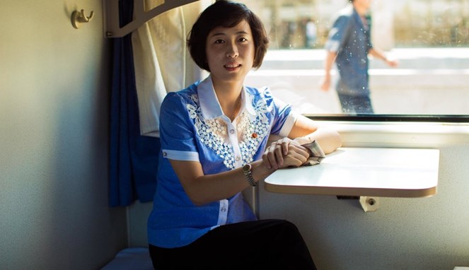 Seorang penumpang wanita di sebuah kereta di Korut [Image Source]