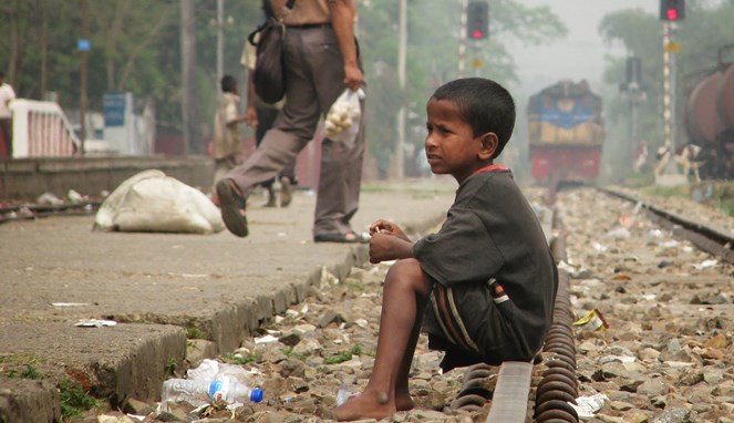 Bocah kecil yang sedang duduk di rel kereta [Image Source]