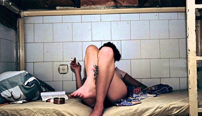 Seorang napi wanita yang merokok [Image Source]