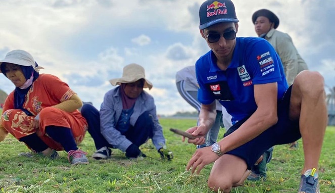 Toprak, juara dunia WSBK, menyiangi rumput bersama warga sekitar. [Sumber Gambar]