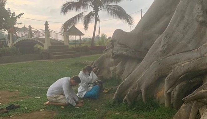 Turis asing asal Rusia meminta maaf di pohon keramat di Bali. [Sumber Gambar]