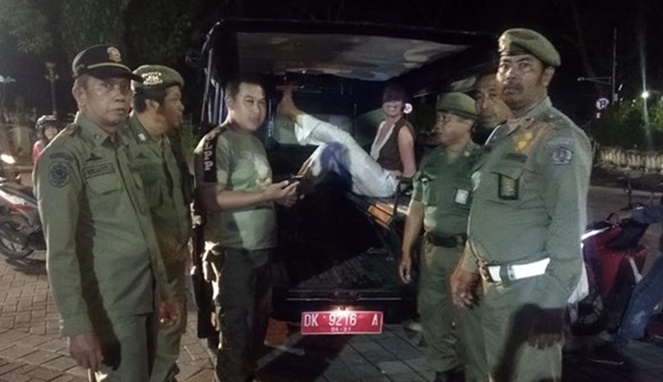 Turis asing yang merusak Patung Catur Muka di Bali diamankan Satpol PP. [Sumber Gambar]